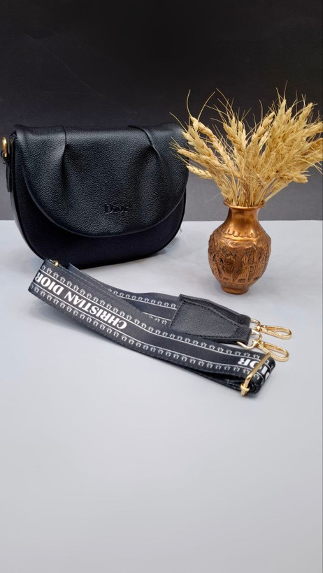 "کیف دوشی دخترانه و زنانه مدل دریسا با چرم مصنوعی، بند بلند مارکدار و طراحی نیمگرد."