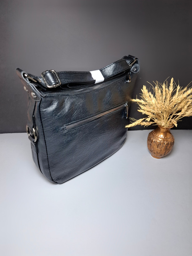 "کیف دوشی زنانه اوورا با طراحی ساده، چرم صنعتی شسته و زیپهای کاربردی، مناسب برای استفاده روزمره و اسپرت."