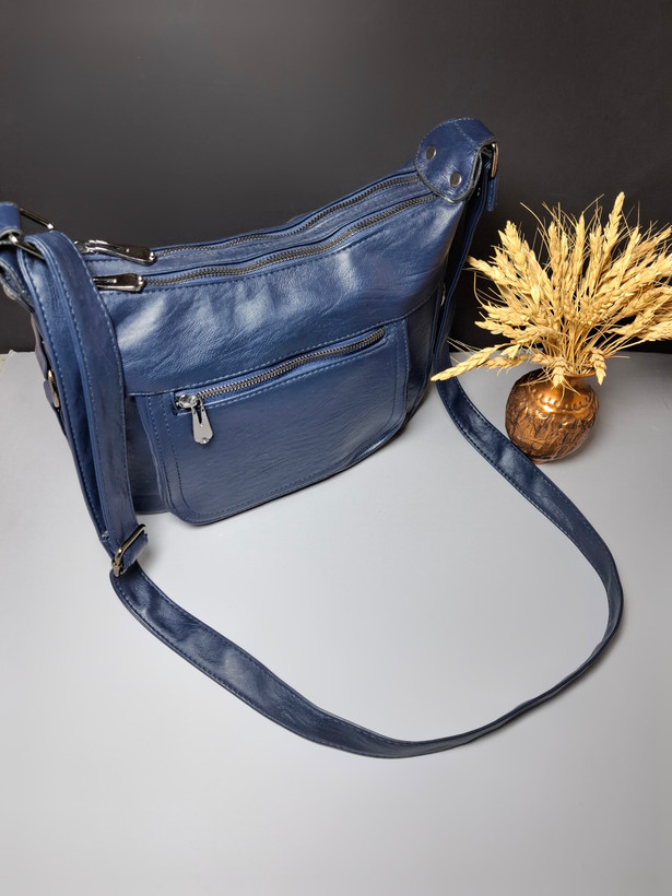 "کیف دوشی زنانه اوورا با طراحی ساده، چرم صنعتی شسته و زیپهای کاربردی، مناسب برای استفاده روزمره و اسپرت."