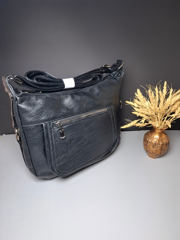 "کیف دوشی زنانه اوورا با طراحی ساده، چرم صنعتی شسته و زیپهای کاربردی، مناسب برای استفاده روزمره و اسپرت."