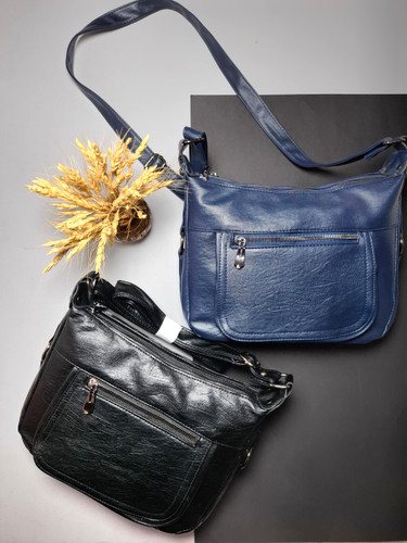 "کیف دوشی زنانه اوورا با طراحی ساده، چرم صنعتی شسته و زیپهای کاربردی، مناسب برای استفاده روزمره و اسپرت."